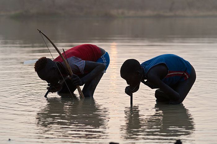 Photo of nomadic cattle herders drinking through pipe filters.