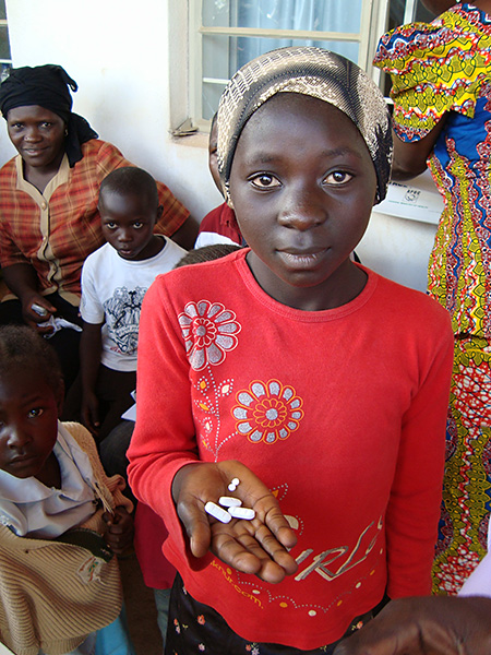 Nigerian girl takes medicine.