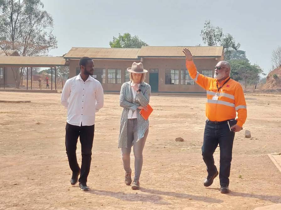 Marx walks mining site with two men.