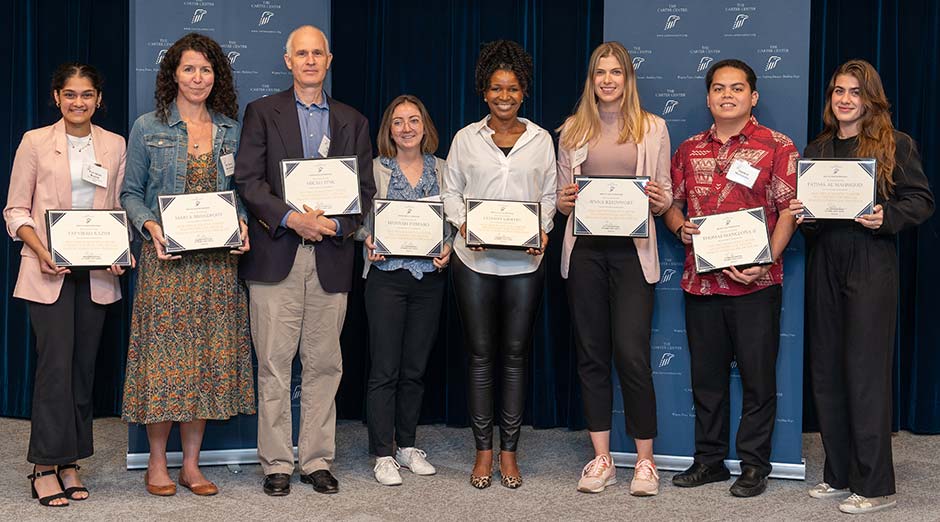 Fellows pose, displaying their certificates.