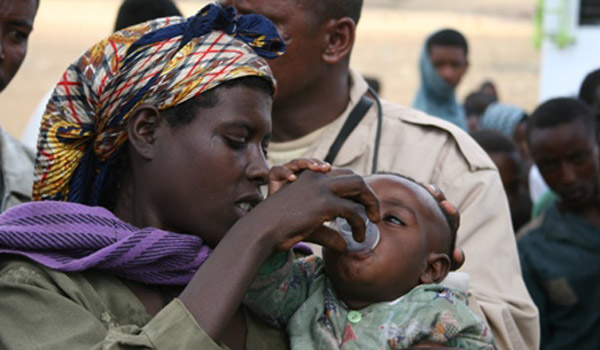 A mother gives her child a dose of Zithromax.